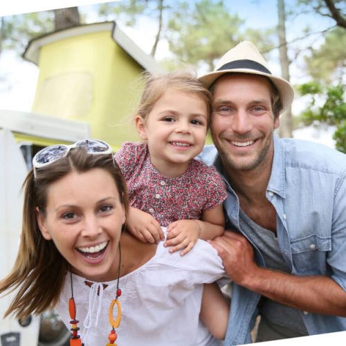 Mom, dad outside with daughter on mom's back and everyone's smile